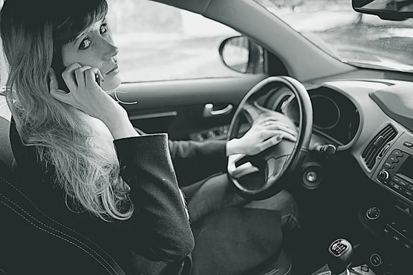 Chica conduciendo el coche y hablando por teléfono — Foto de Stock