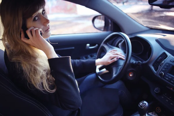 Mädchen fährt Auto und telefoniert — Stockfoto