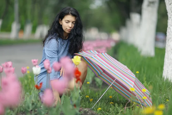 Brunette woman with colorful umbrella — Stock fotografie