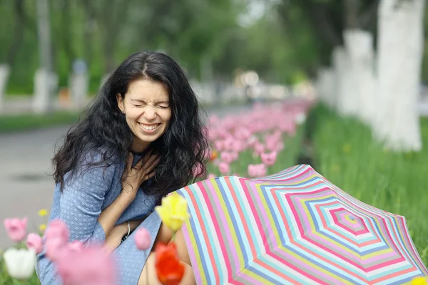 Brunette woman with colorful umbrella — Stock fotografie