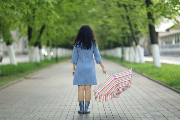Молодая женщина ходит с зонтиком — стоковое фото