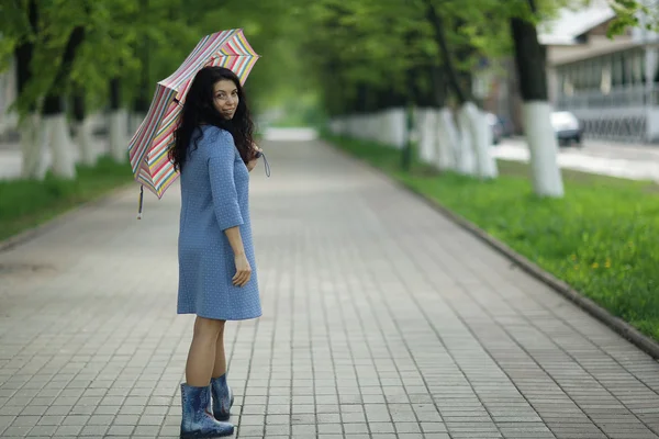 Young woman walking with umbrella — Stock Photo, Image