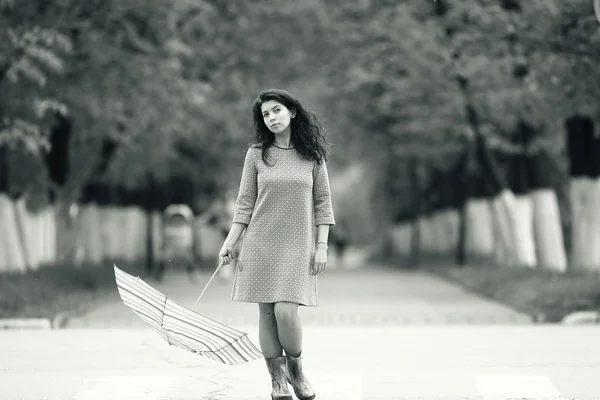 Young woman walking with umbrella — Stock Photo, Image