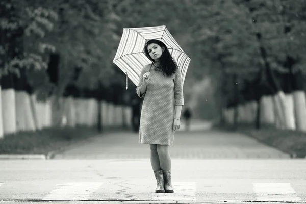 Jovem caminhando com guarda-chuva — Fotografia de Stock