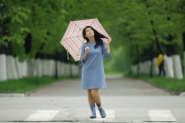 Young woman walking with umbrella — Stock Photo, Image