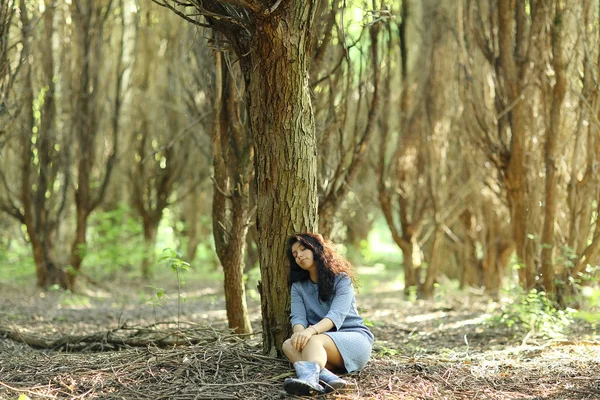 Женщина, сидящая у дерева — стоковое фото