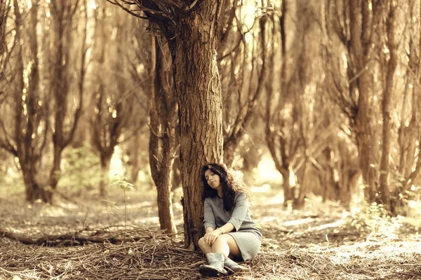 Mujer sentada cerca del árbol — Foto de Stock