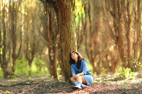 Vrouw zitten in de buurt van de boom — Stockfoto