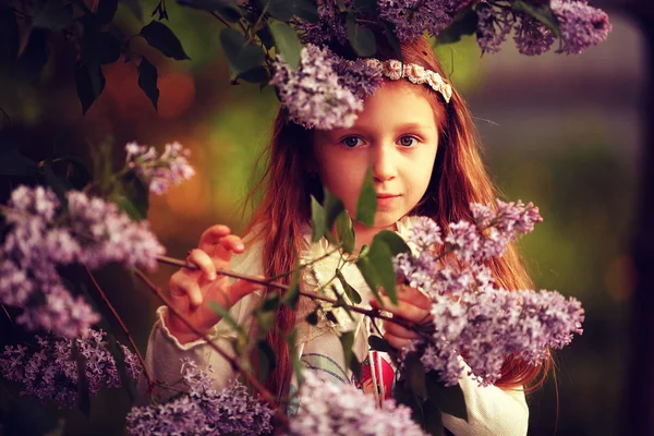 Small girl with lilac flowers — 图库照片