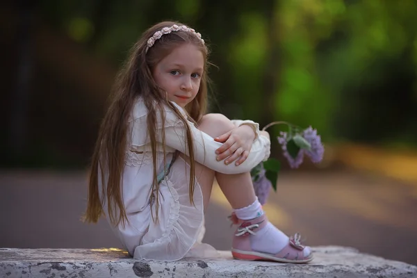 Flickan sitter i sommaren park — Stockfoto