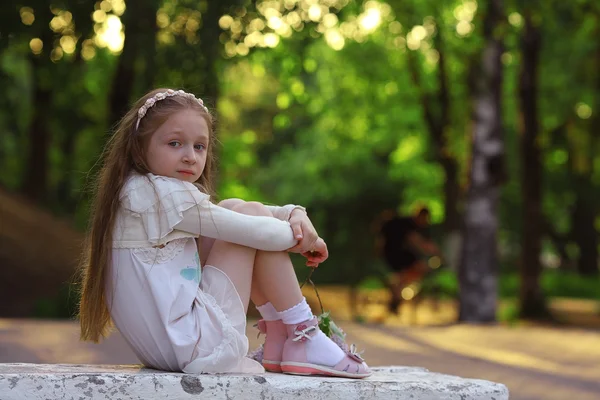 Meisje zit in de zomer park — Stockfoto