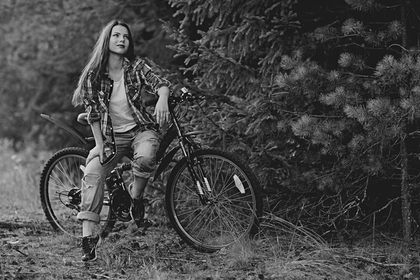 Fiatal lány egy sport kerékpár nyári erdőben — Stock Fotó