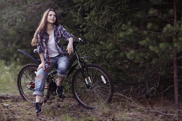 Νεαρό κορίτσι σε ένα ποδήλατο αθλητισμού στο δάσος ένα καλοκαίρι — Φωτογραφία Αρχείου
