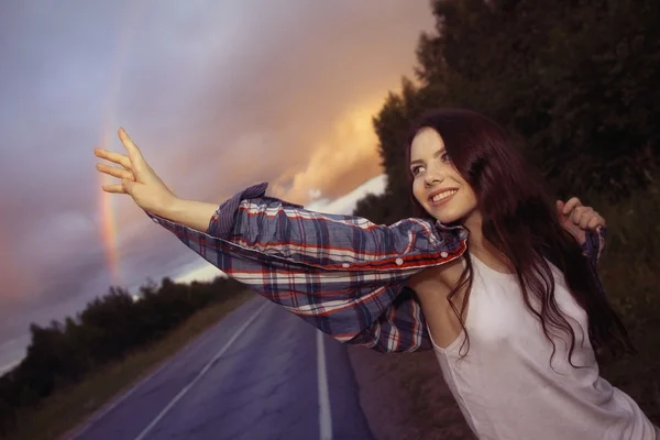 Jovem adolescente e arco-íris na estrada — Fotografia de Stock
