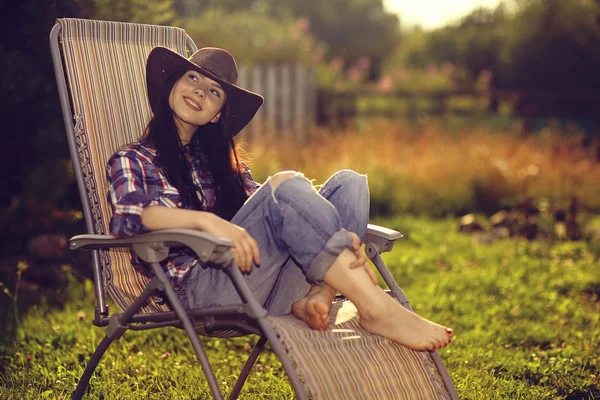 Girl in a wide hat resting on a sun — Stock Photo, Image