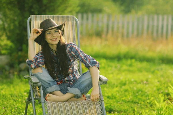 Girl in a wide hat resting on a sun — Stock Photo, Image