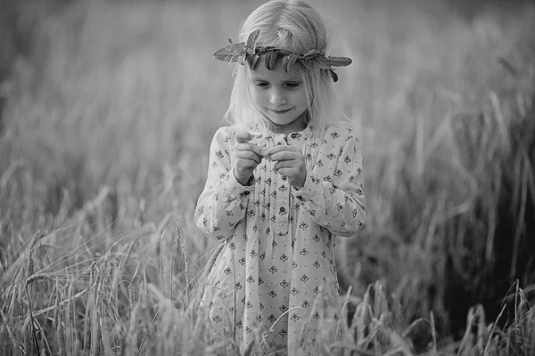 Blonde little girl in the field with spikelets — Stock Photo, Image