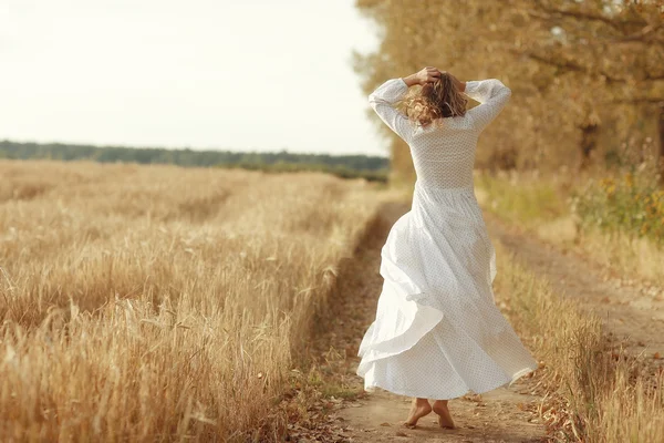 Mädchen tanzt im weißen Kleid auf einem Feld — Stockfoto