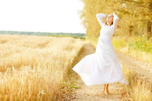 Retrato de uma menina bonita em um vestido ao pôr do sol — Fotografia de Stock