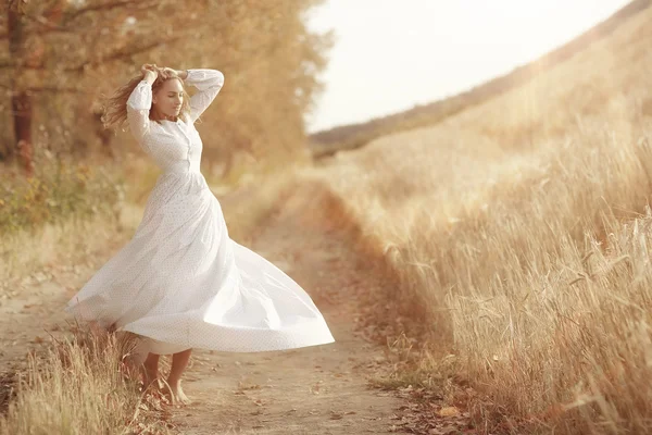 Fille dansant dans un champ en robe blanche — Photo