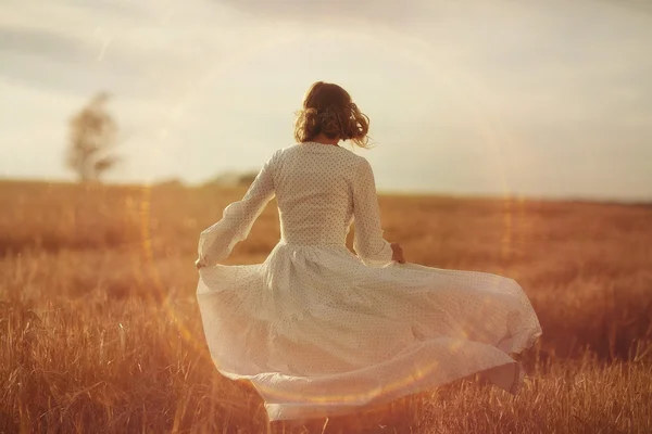 Fille dansant dans un champ en robe blanche — Photo