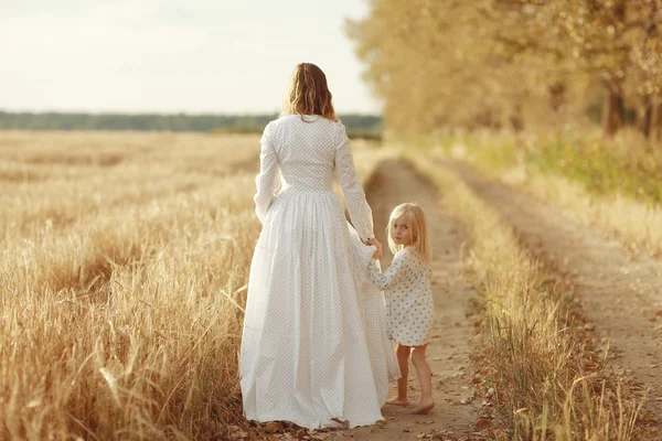 Dívka je se svou matkou v poli podzimní — Stock fotografie