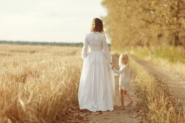 Dívka je se svou matkou v poli podzimní — Stock fotografie