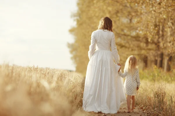 Meisje is met haar moeder in de herfst veld — Stockfoto