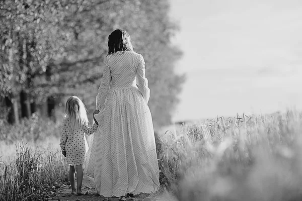 Menina está com sua mãe no campo de outono — Fotografia de Stock