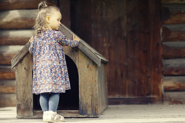 Niña y perro pequeño, casa del perro —  Fotos de Stock