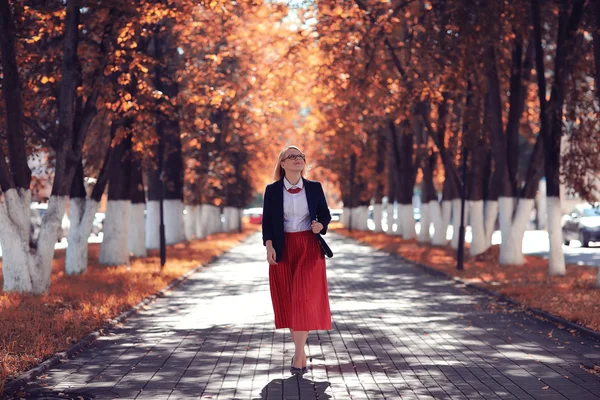 Mulher andando em um parque ensolarado — Fotografia de Stock