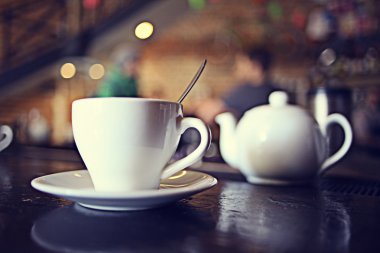 Arka planda bulanık bir kafede bir fincan çay