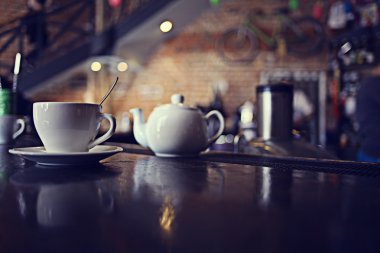 Arka planda bulanık bir kafede bir fincan çay