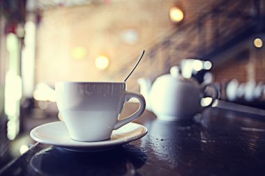 Arka planda bulanık bir kafede bir fincan çay