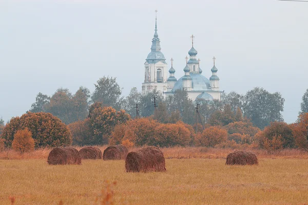 Yellow autumn field with church — Stock Photo, Image