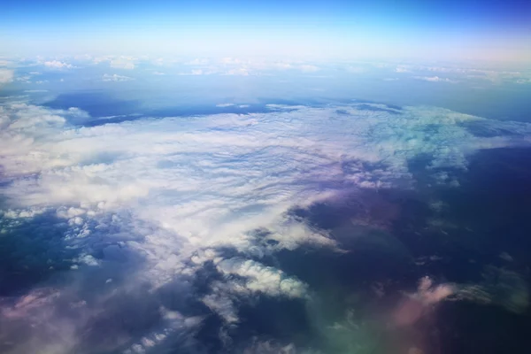 view of the airplane window at the horizon and clouds