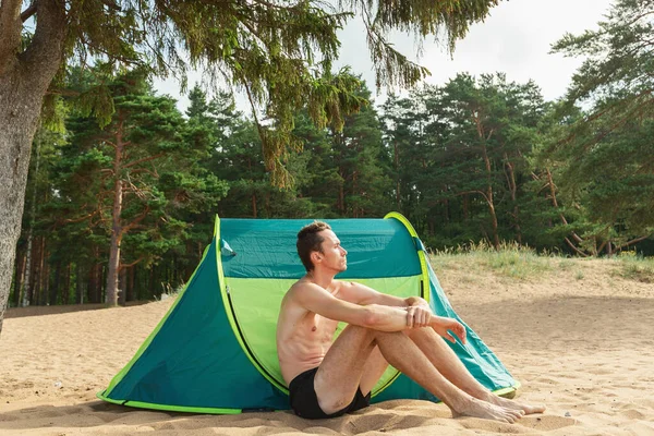 Homem Caucasiano Lindo Sentado Areia Debaixo Árvore Por Tenda Verde — Fotografia de Stock