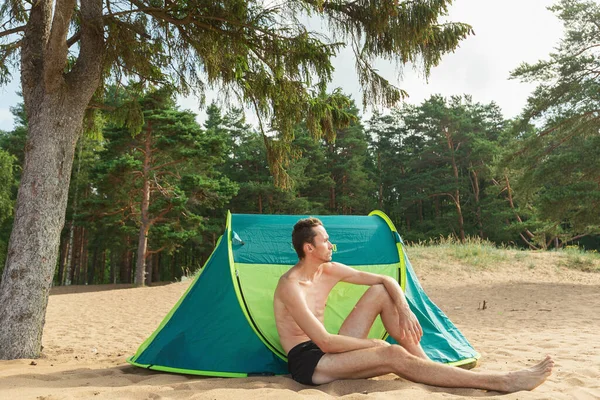 Homem Caucasiano Lindo Sentado Areia Debaixo Árvore Por Tenda Verde — Fotografia de Stock