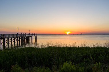 Daphne, Alabama 'daki Mobile Körfezi' nin doğu kıyısında gün batımında iskele. 