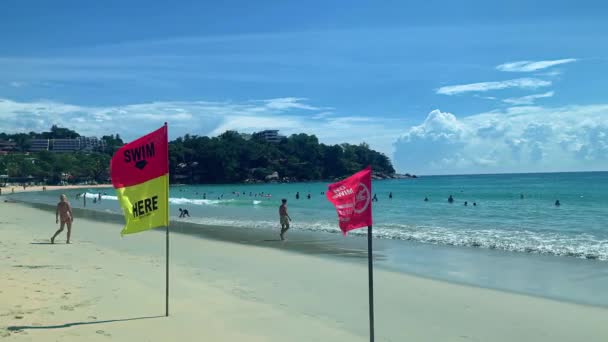 Mensen toeristen hebben een goede tijd in zee en op het strand met vlaggen in tropische resort. — Stockvideo