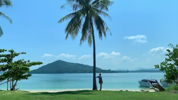 Samotny młoda ładna kobieta relaks w ośrodku, patrząc na piękny widok opierając się na palmy kokosowej — Wideo stockowe