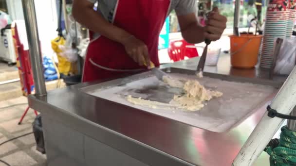 Азиатский мужчина делает мороженое, стоя в уличном кафе в Таиланде. — стоковое видео