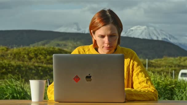 옥외에 랩탑 컴퓨터를 가지고 있는 여자가 해질 때 공책을 사용 한다 — 비디오