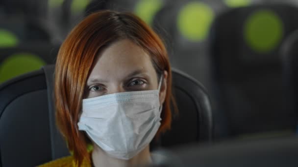 Счастливая дама в маске в самолете Путешествие во время карантина — стоковое видео
