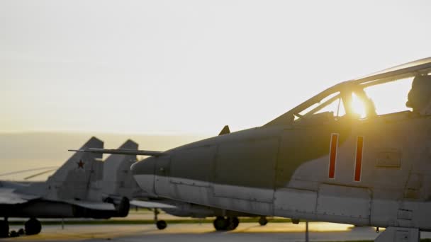 Vliegende militaire machines vechten vliegtuig op veld bij zonsondergang — Stockvideo