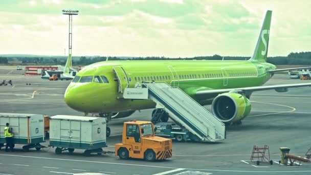 Moskow, Rusland, 30 augustus 2020, Close-upzicht op S7-vliegtuig dat op de luchthaven staat en mensen die in de buurt werken. — Stockvideo