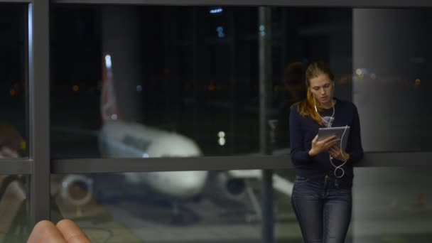Χρήση νέας συσκευής σε ταξιδιωτική γυναίκα με ακουστικά και tablet — Αρχείο Βίντεο