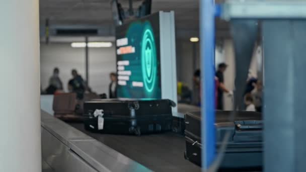 Closeup view of baggage moving on belt and people walking at airport interior. — Stock Video