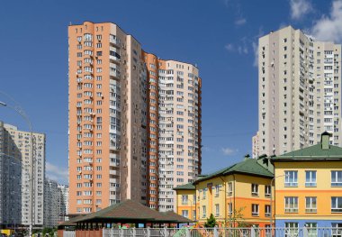 Düz binaları olan modern bir apartman dairesi. New Lüks Ev ve Ev Kompleksinin ayrıntıları. Şehir Emlak ve Mimarisi 'nin bir parçası. Mavi gökyüzü