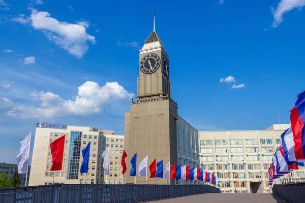 Krasnoyarsk, Rusya - 11 Mayıs 2020: Şehir Saat Kulesi veya çok renkli bayraklarla süslenmiş yaya köprüsü ile Krasnoyarsk Big Ben. Rusların üç renkli renkleri. Tatiller için şehir dekorasyonu